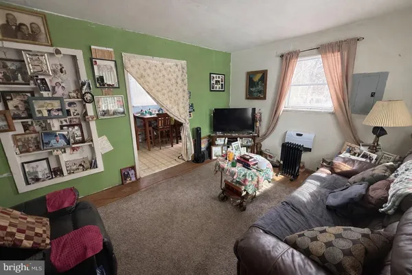 a living room with furniture a window and a flat screen tv