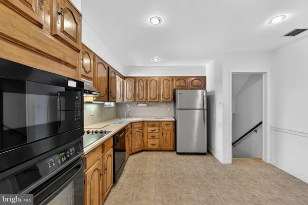 a kitchen with stainless steel appliances granite countertop a refrigerator a stove and a sink