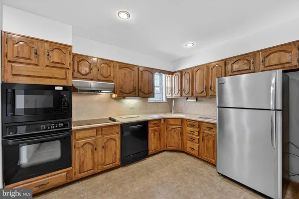 a kitchen with stainless steel appliances granite countertop a refrigerator a stove a sink and a microwave