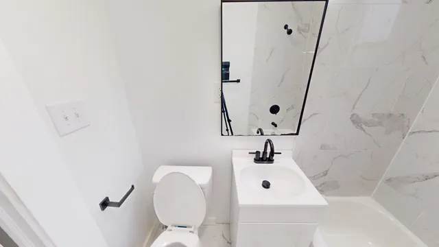 a bathroom with a sink mirror vanity and toilet