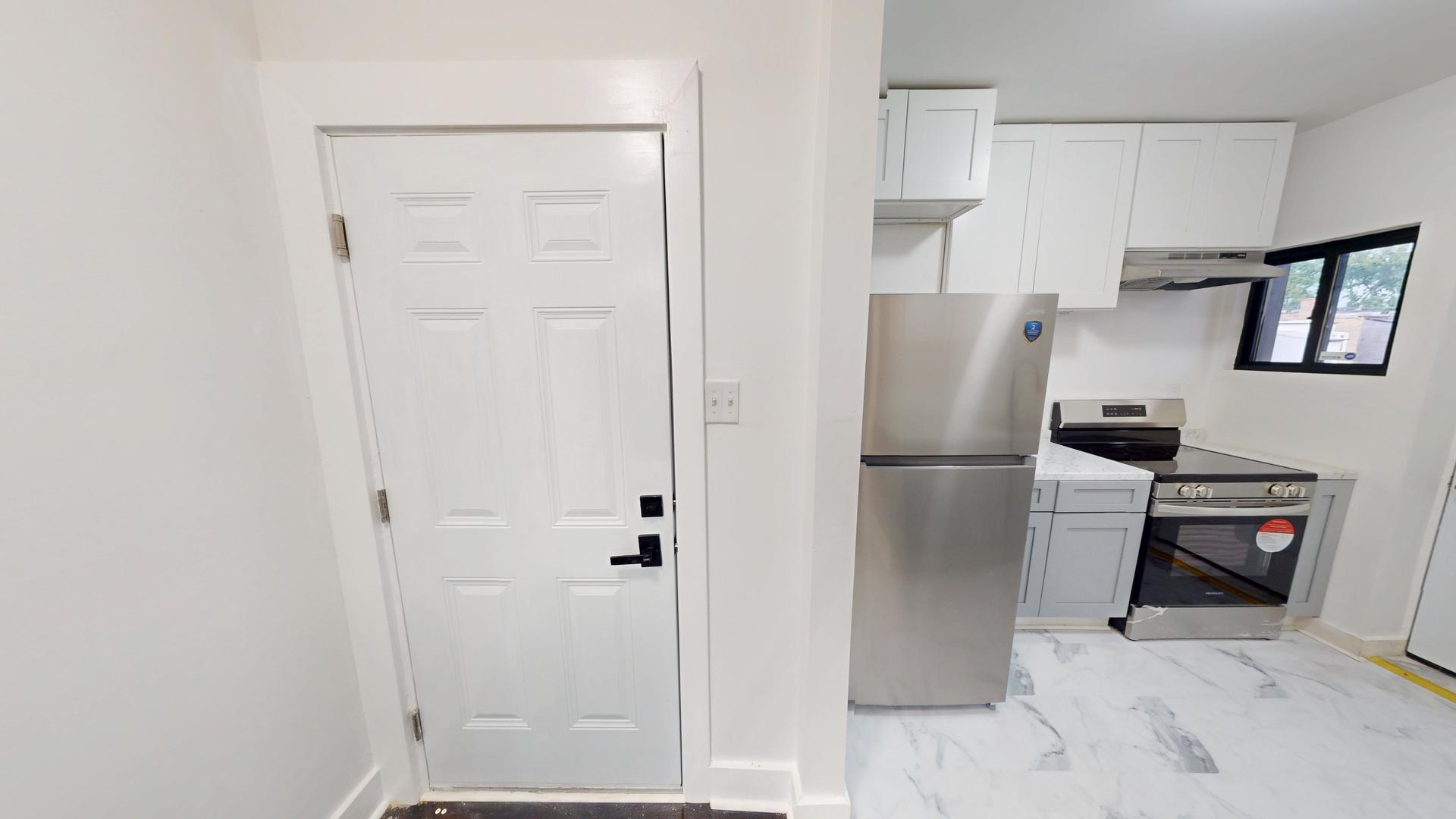 2401 East 75th Street, Unit 3 Chicago, IL 60649 - Photo 4 of 14 a kitchen with stainless steel appliances a refrigerator and cabinets
