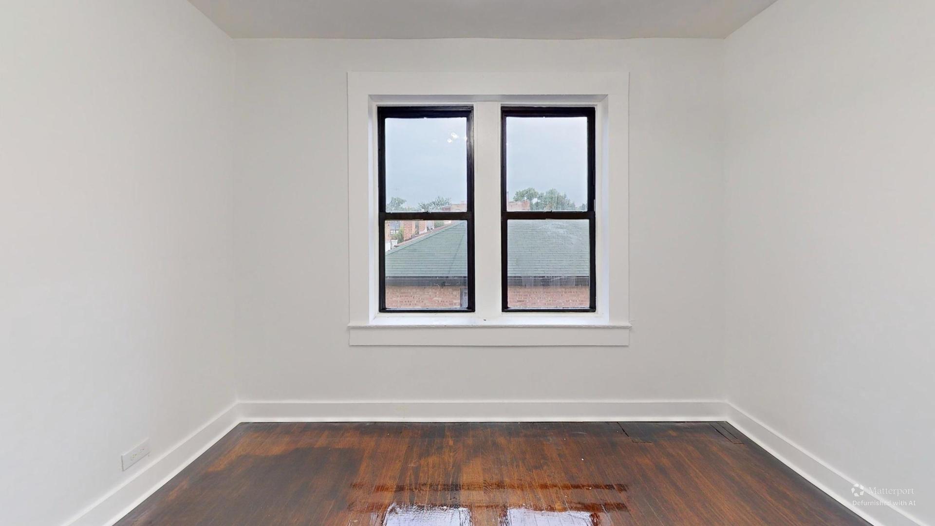 2401 East 75th Street, Unit 3 Chicago, IL 60649 - Photo 5 of 14 an empty room with wooden floor and windows