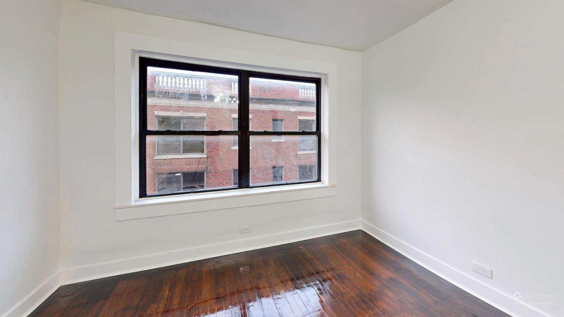 2401 East 75th Street, Unit 3 Chicago, IL 60649 - Photo 8 of 14 a view of an empty room with wooden floor and a window