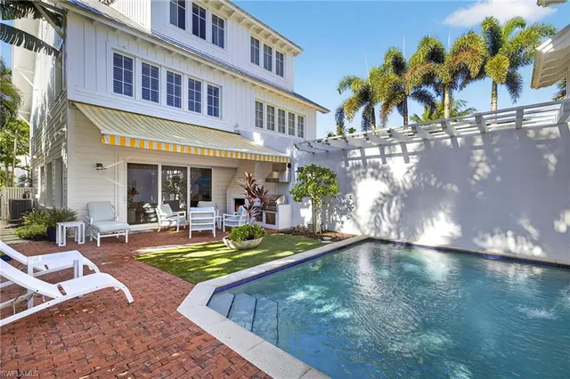 a view of a house with swimming pool and sitting area