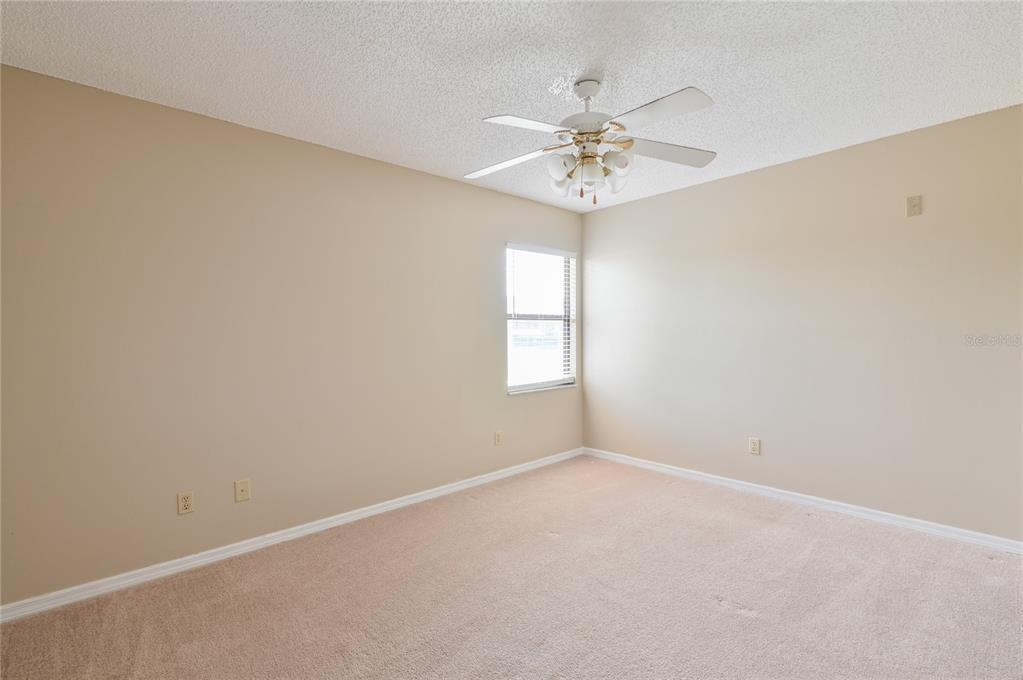 11001 Southeast Sunset Harbor Road, Unit H52 Summerfield, FL 34491 - Photo 21 of 31 an empty room with a chandelier fan and windows