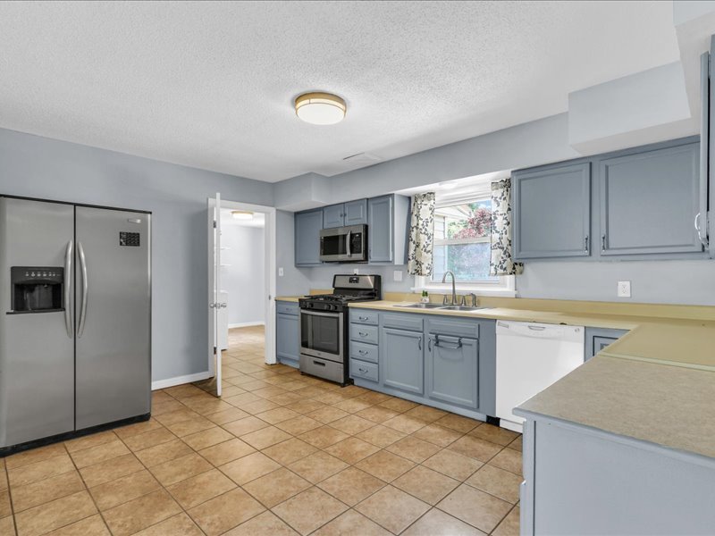 615 Breen Drive Champaign, IL 61820 - Photo 9 of 29 a kitchen with stainless steel appliances granite countertop a stove top oven a sink dishwasher a refrigerator and cabinets with wooden floor