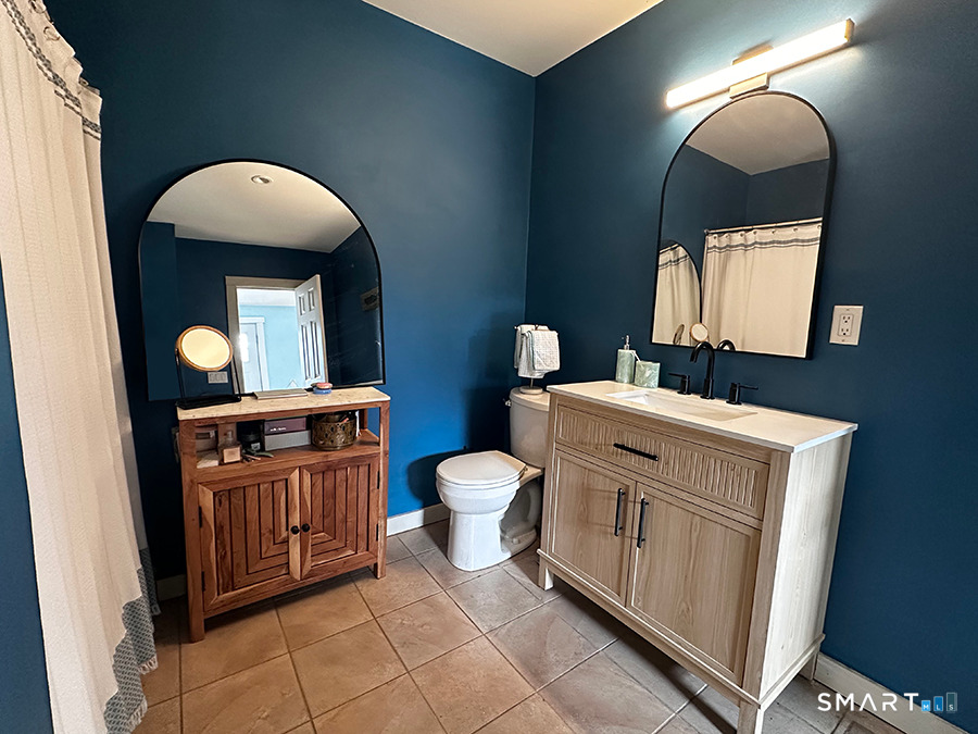 79 Wesley Avenue Westbrook, CT 06498 - Photo 19 of 33 a bathroom with a toilet a sink a mirror and vanity