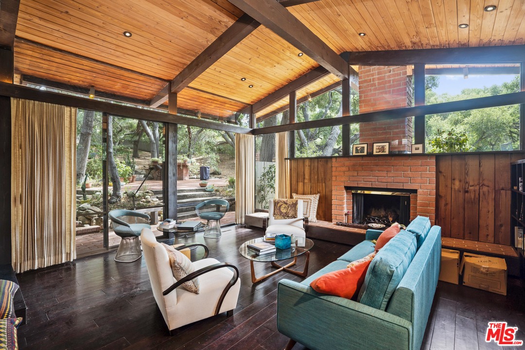 481 Cold Canyon Road Calabasas, CA 91302 - Photo 2 of 44 a living room with furniture a fireplace and a floor to ceiling window