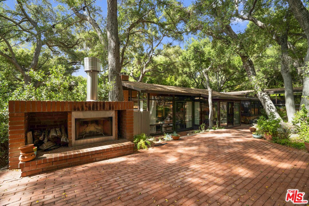 481 Cold Canyon Road Calabasas, CA 91302 - Photo 16 of 44 a front view of a house with a yard and potted plants