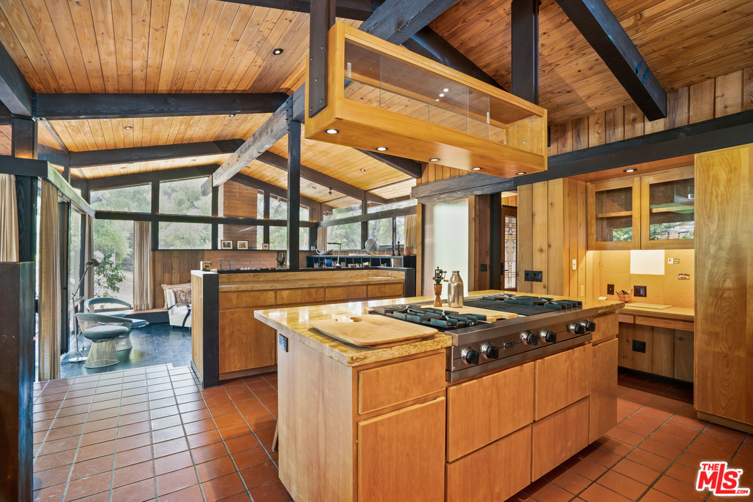 481 Cold Canyon Road Calabasas, CA 91302 - Photo 4 of 44 a kitchen that has a sink a stove and a table with chairs
