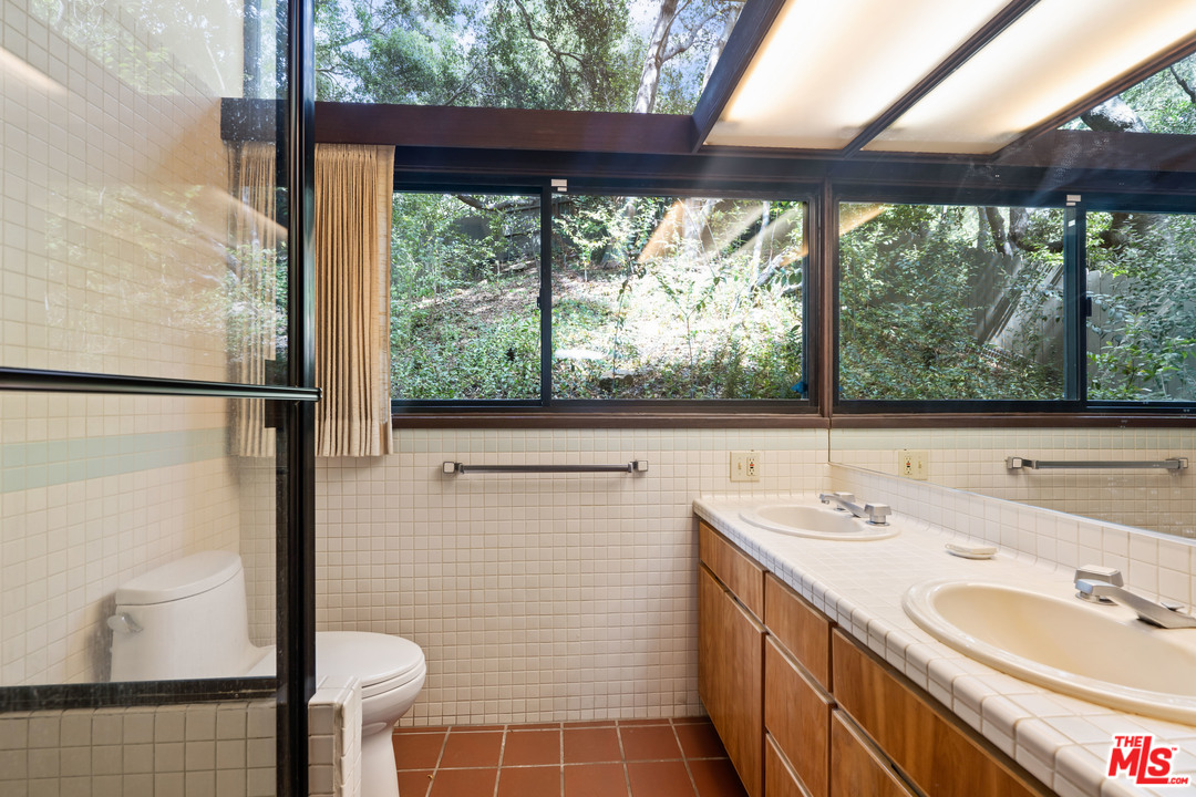 481 Cold Canyon Road Calabasas, CA 91302 - Photo 32 of 44 a bathroom with a sink and a large mirror