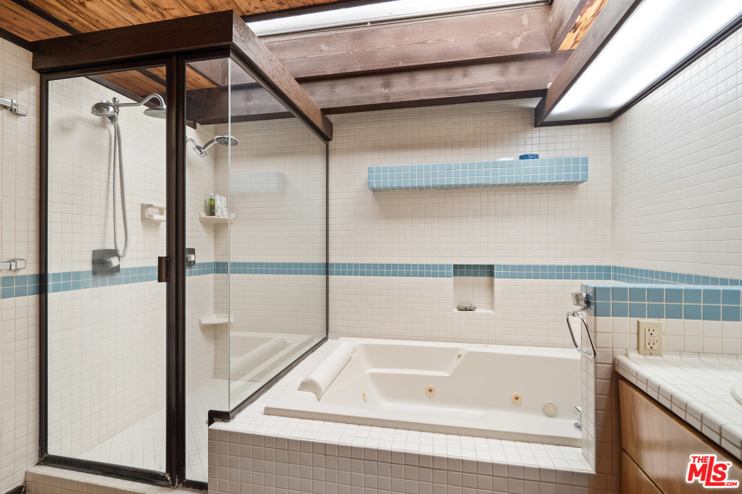 481 Cold Canyon Road Calabasas, CA 91302 - Photo 35 of 44 a bathroom with a tub and a shower