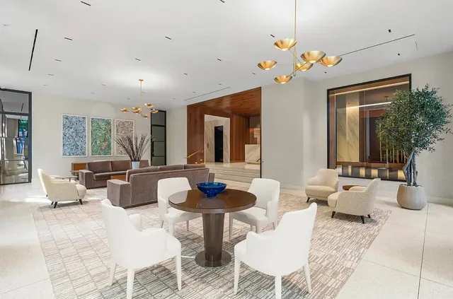 front view of a brick house with a yard and large trees