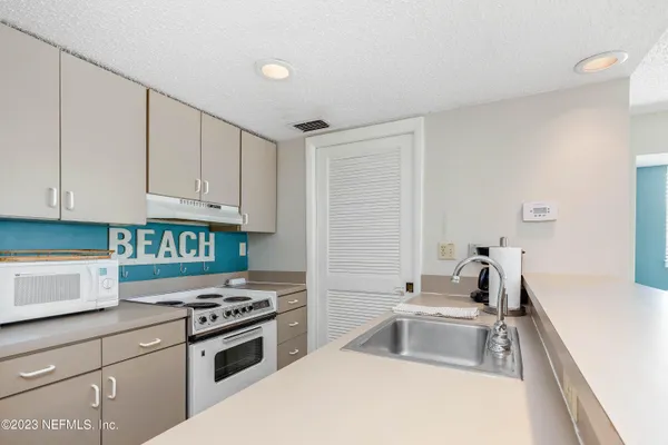 a kitchen with granite countertop a sink stove and cabinets