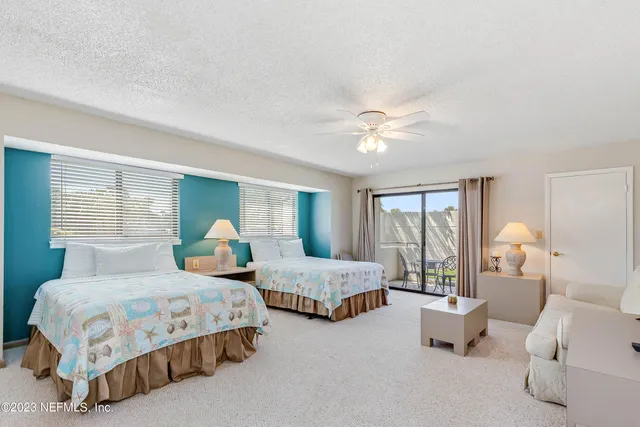 a bedroom with two beds and a large window