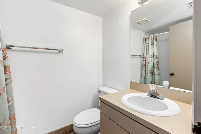 a bathroom with a toilet a sink and a mirror