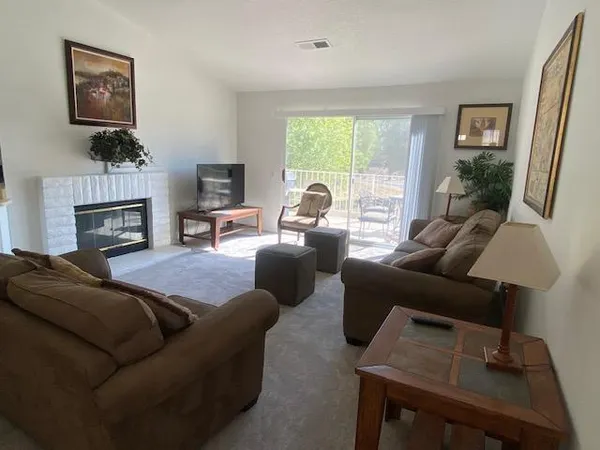 a living room with furniture a large window and a fireplace