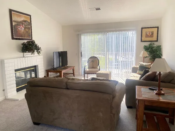 a living room with furniture a fireplace and a flat screen tv