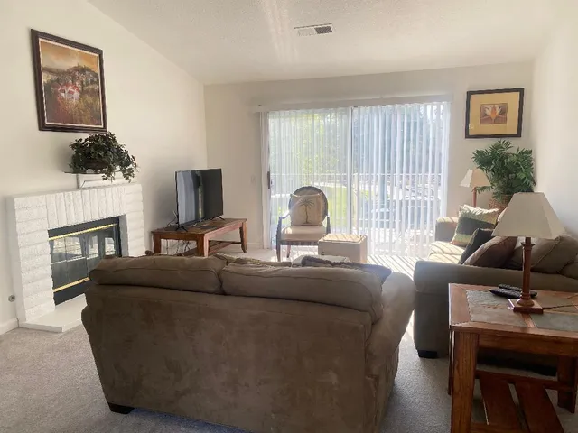 a living room with furniture a fireplace and a flat screen tv