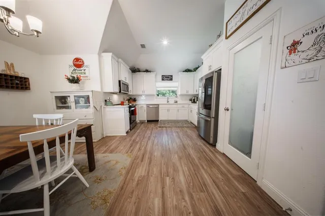 a kitchen with wooden floors and refrigerator