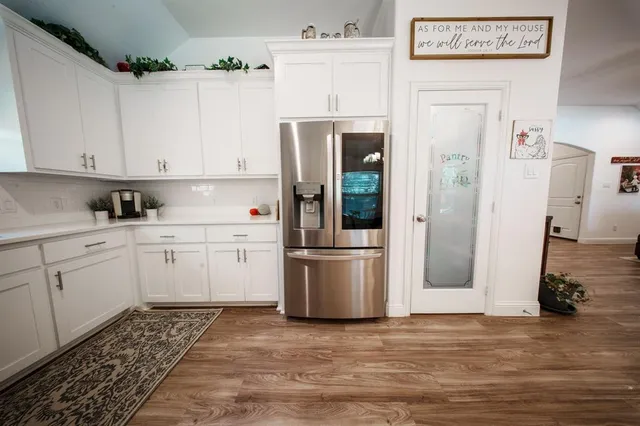 a kitchen with a refrigerator sink and cabinets