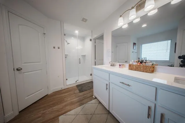 a bathroom with a sink a mirror and a shower