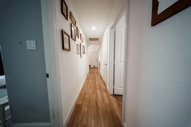 a view of a hallway with wooden floor and stairs