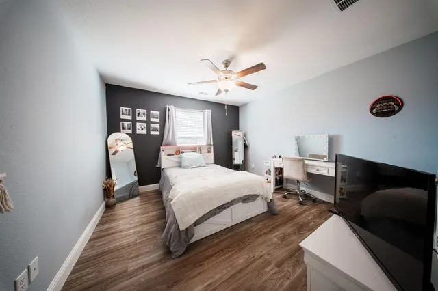 a spacious bedroom with a bed and a ceiling fan