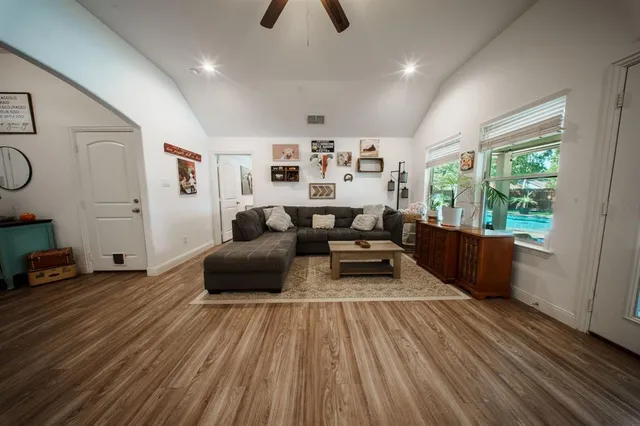 a living room with furniture and a wooden floor