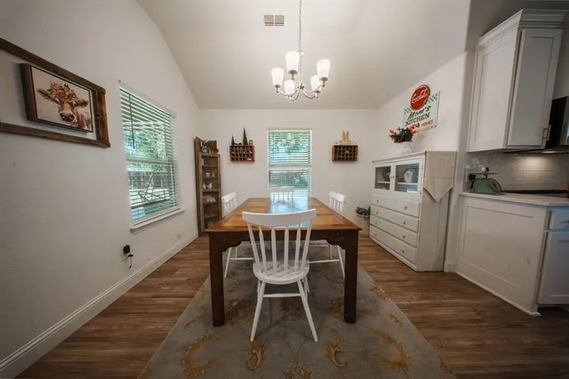 a view of a dining room with furniture a chandelier and wooden floor