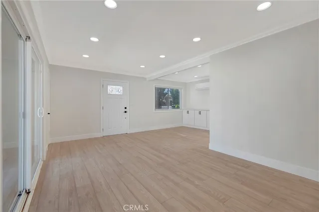a view of empty room with wooden floor