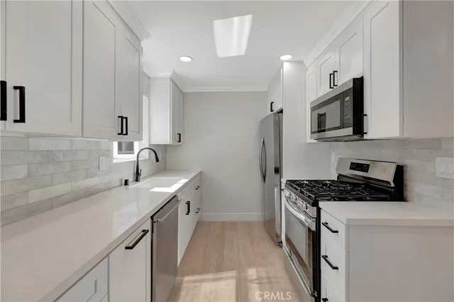 a kitchen with stainless steel appliances a sink stove and cabinets