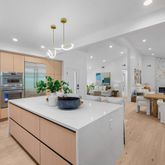 a view of kitchen with kitchen island stainless steel appliances sink table and chairs