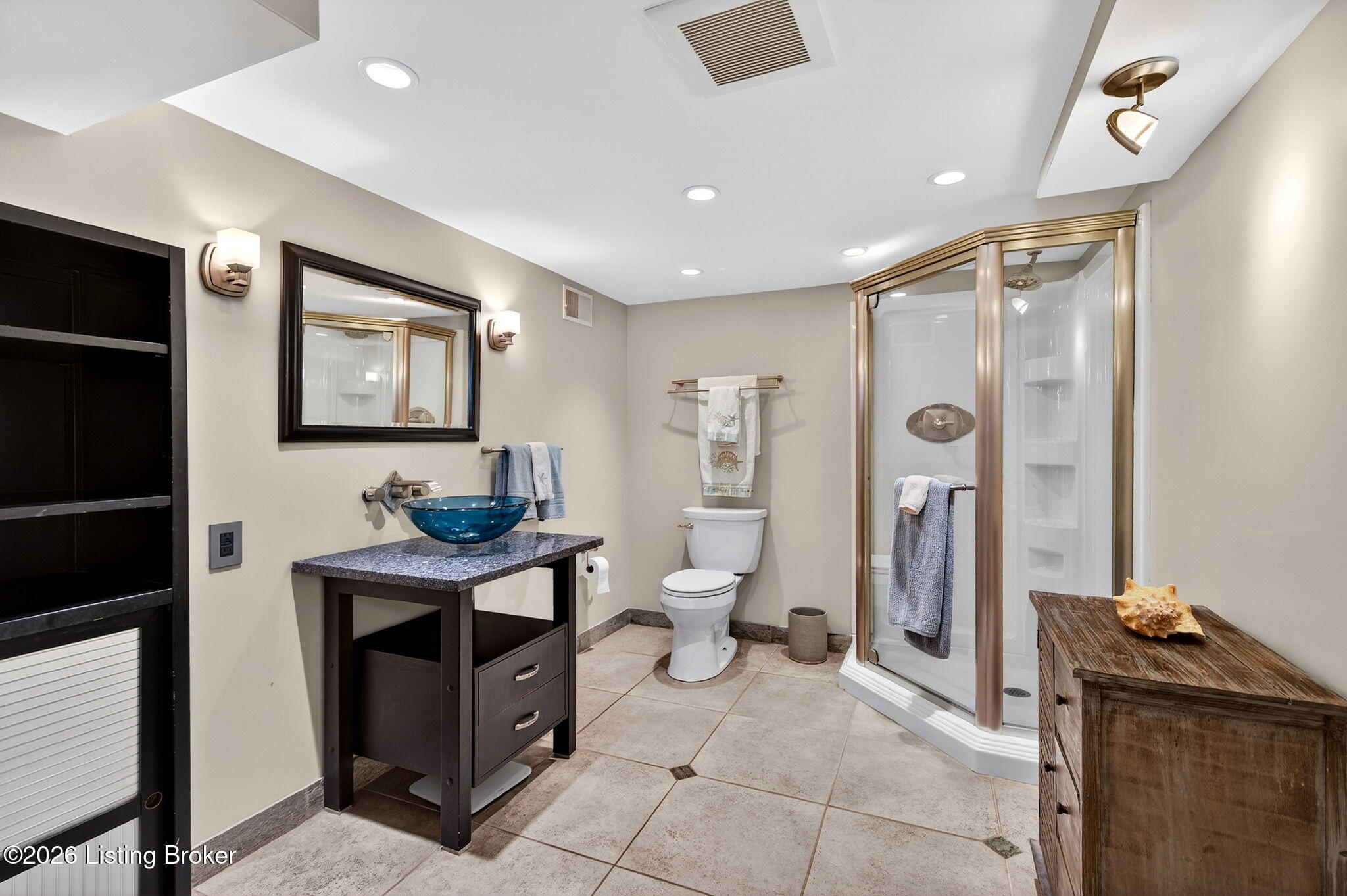 3101 Bobolink Road Louisville, KY 40213 - Photo 43 of 57 A striking blue glass vessel sink, dark granite vanity, and framed mirror combine for a sophisticated look