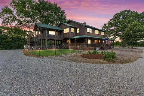 a front view of a house with a yard and potted plants