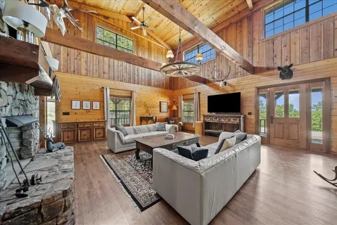 a living room with couches a flat screen tv and kitchen view