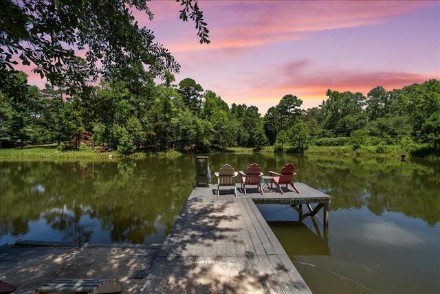 a wooden deck with lake view and a trees
