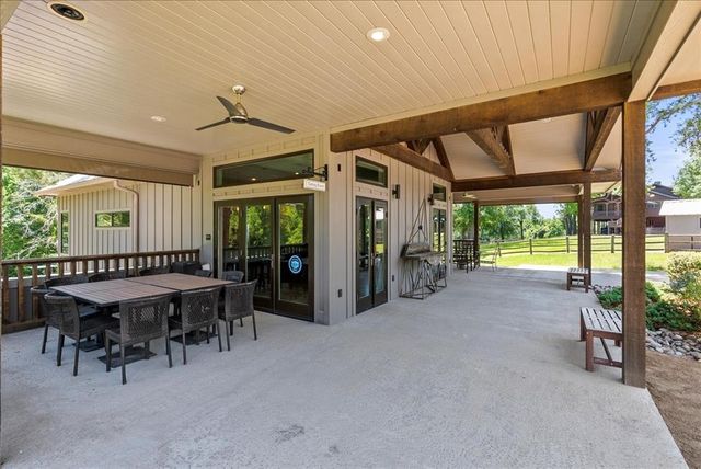 a dining area with furniture large windows and a rug