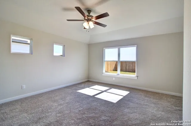 a view of an empty room with a ceiling fan
