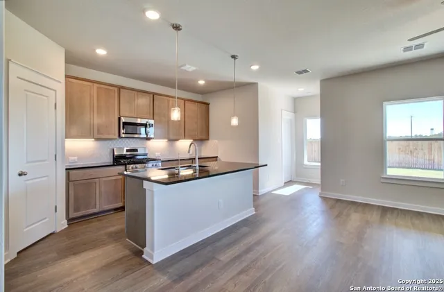 a large kitchen with stainless steel appliances granite countertop a stove a sink and a refrigerator