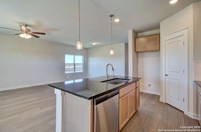a kitchen that has a sink a stove and a wooden floor