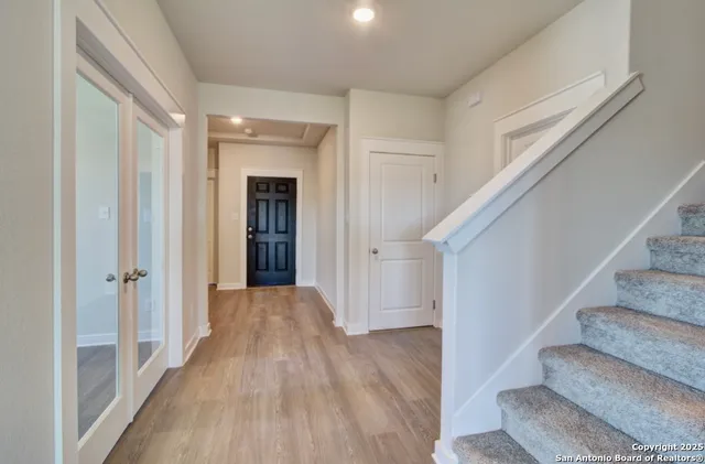 a view of a hallway with wooden floor and entryway