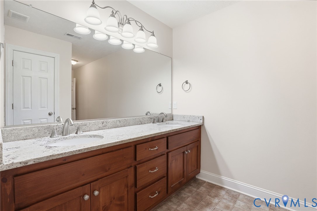 10326 Gould Hill Road Hanover, VA 23069 - Photo 23 of 43 a bathroom with a granite countertop sink a large mirror and vanity