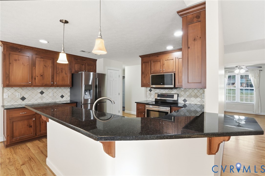 10326 Gould Hill Road Hanover, VA 23069 - Photo 10 of 43 a kitchen with stainless steel appliances granite countertop a sink stove and refrigerator