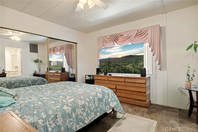 a bedroom with a bed and large windows