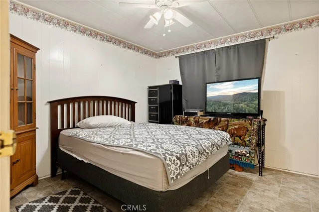 a bedroom with a bed and a flat tv screen on dresser