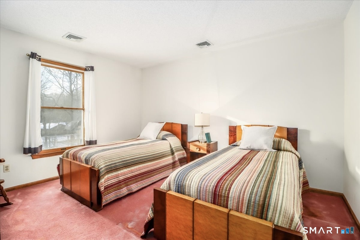 185 Quaker Farms Road Oxford, CT 06478 - Photo 19 of 40 a bedroom with two beds and a window