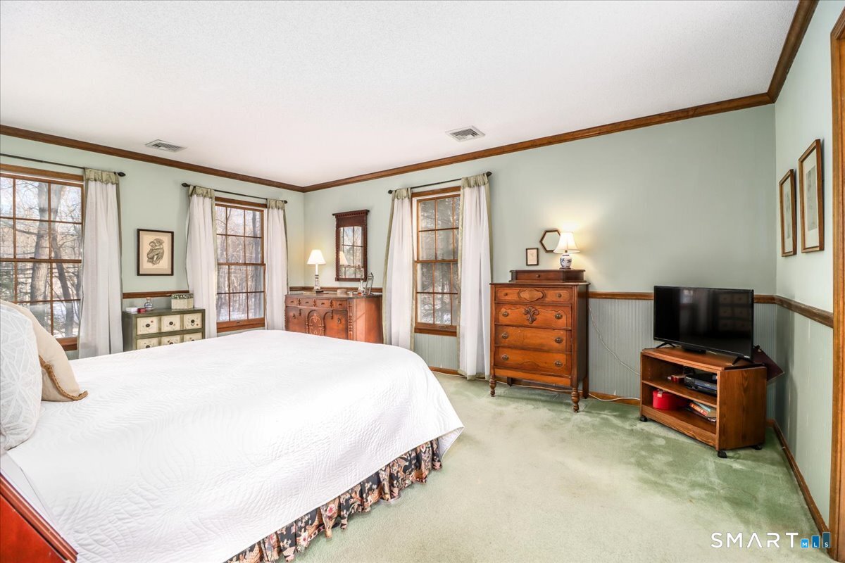 185 Quaker Farms Road Oxford, CT 06478 - Photo 24 of 40 a spacious bedroom with a bed a dresser and a book shelf