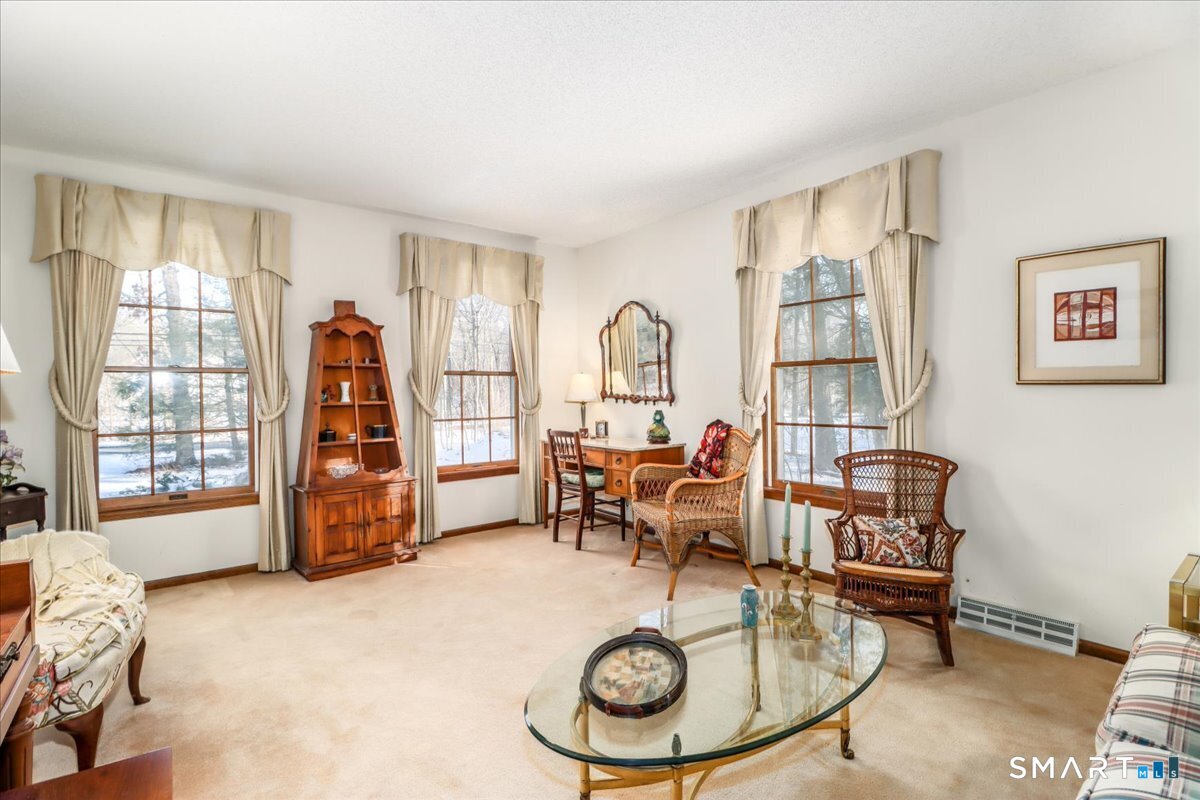 185 Quaker Farms Road Oxford, CT 06478 - Photo 6 of 40 a living room with furniture a fireplace and gym equipment