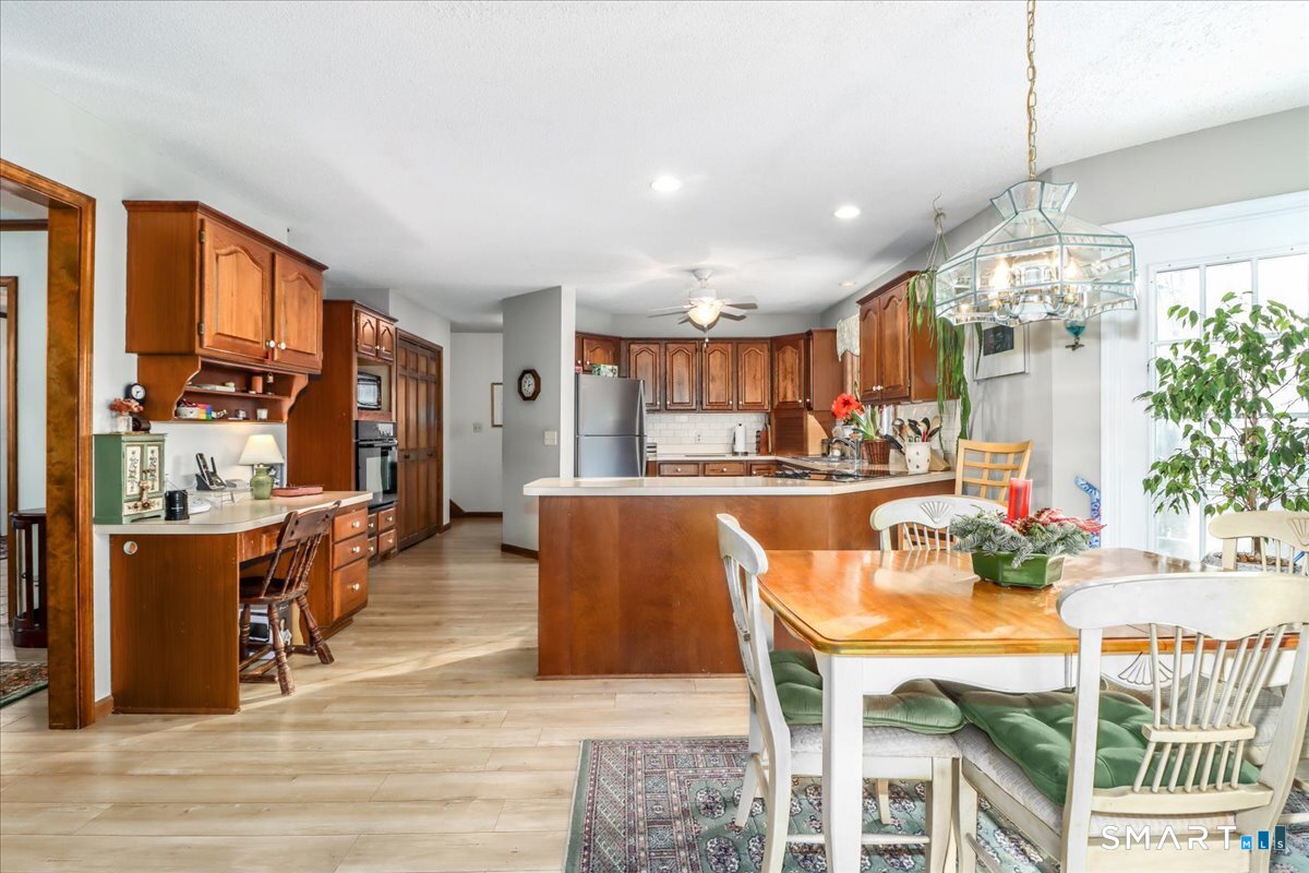 185 Quaker Farms Road Oxford, CT 06478 - Photo 10 of 40 a dining room with stainless steel appliances kitchen island granite countertop a dining table chairs and view of living room